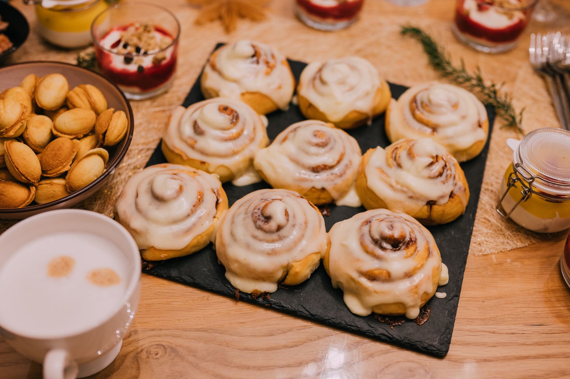 Small iced buns on a slate tray with nuts and a drink