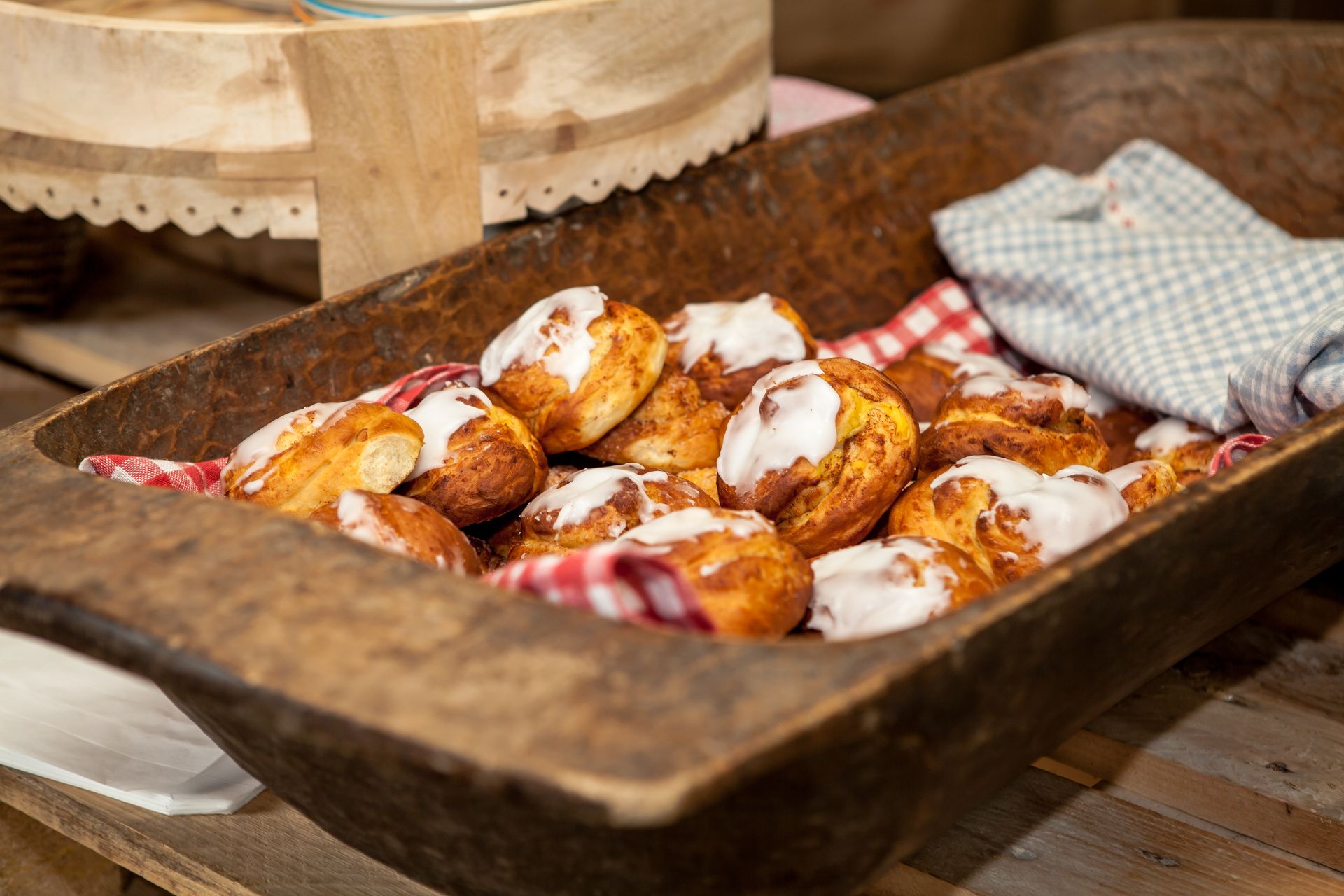 Iced pastries piled in a rustic wooden tray