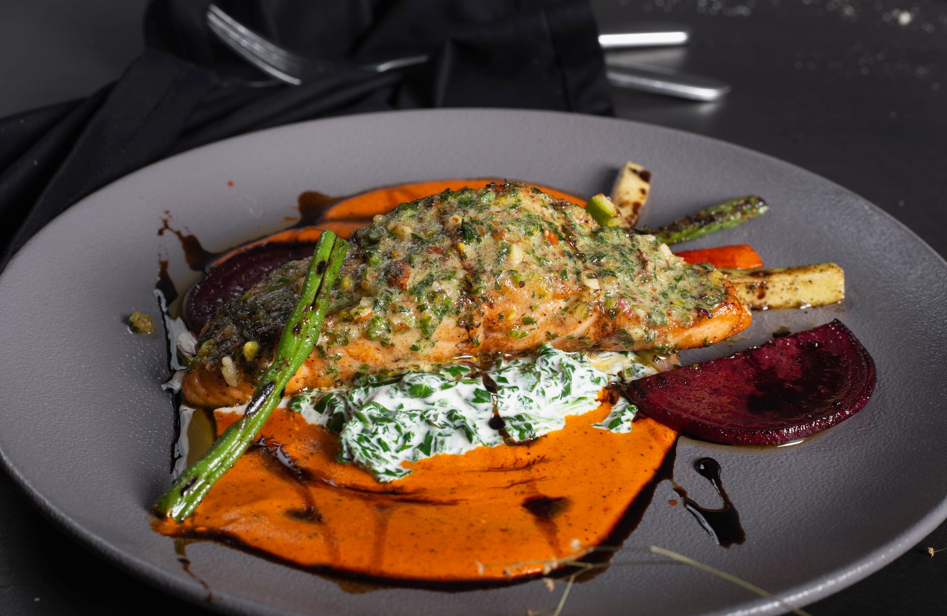 Herb crusted fish on a bed of creamed spinach with roasted beets