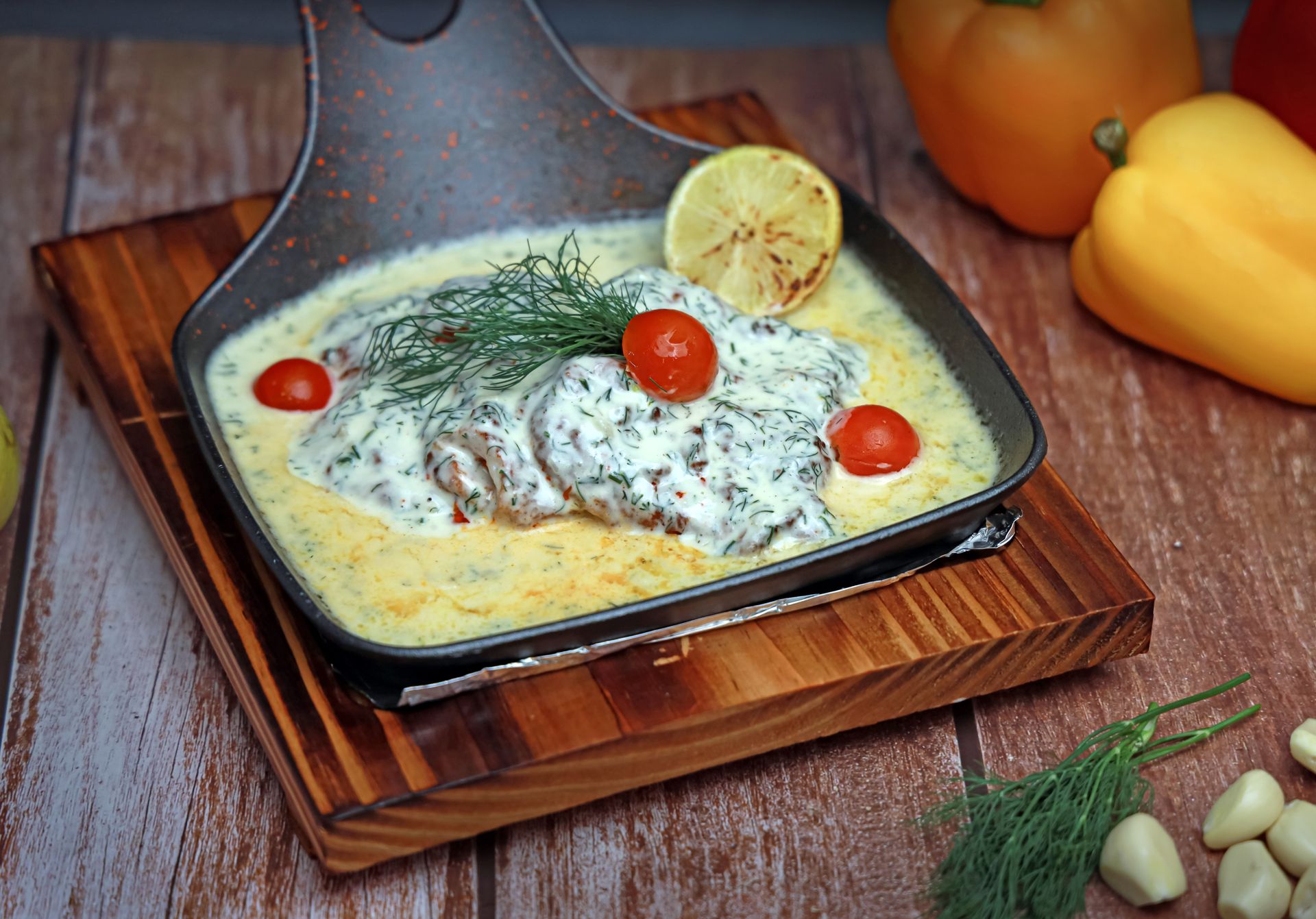 Fish fillet covered in a lemon dill cream sauce in a cast iron pan