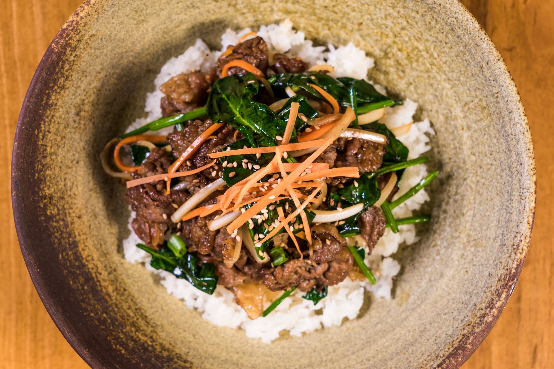 Ground beef and rice bowl with spinach, carrots and a sweet soy glaze