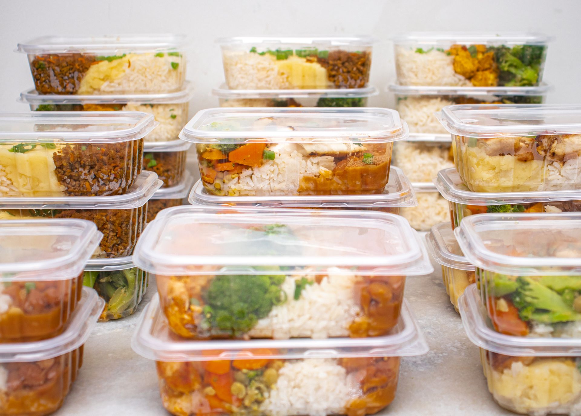 Stacked meal prep containers filled with grains and vegetables