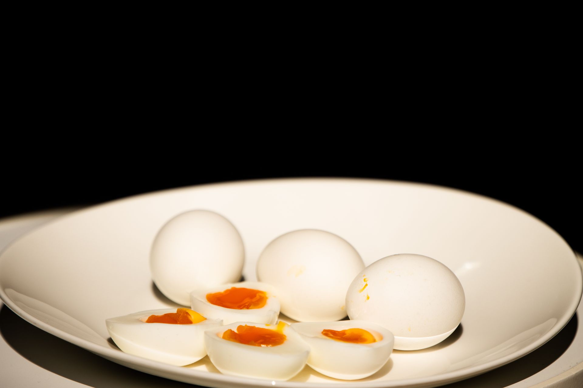 Instant Pot hacks: peeled hard boiled eggs cut in half on a white plate