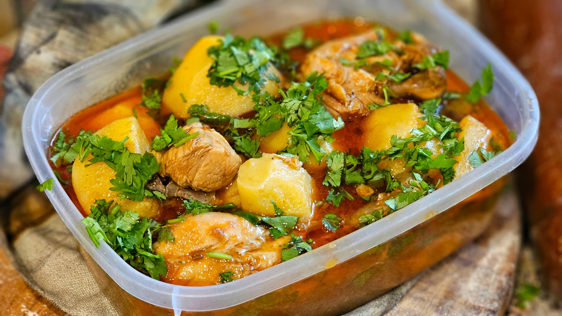 Chicken stew with potatoes and herbs in a glass container