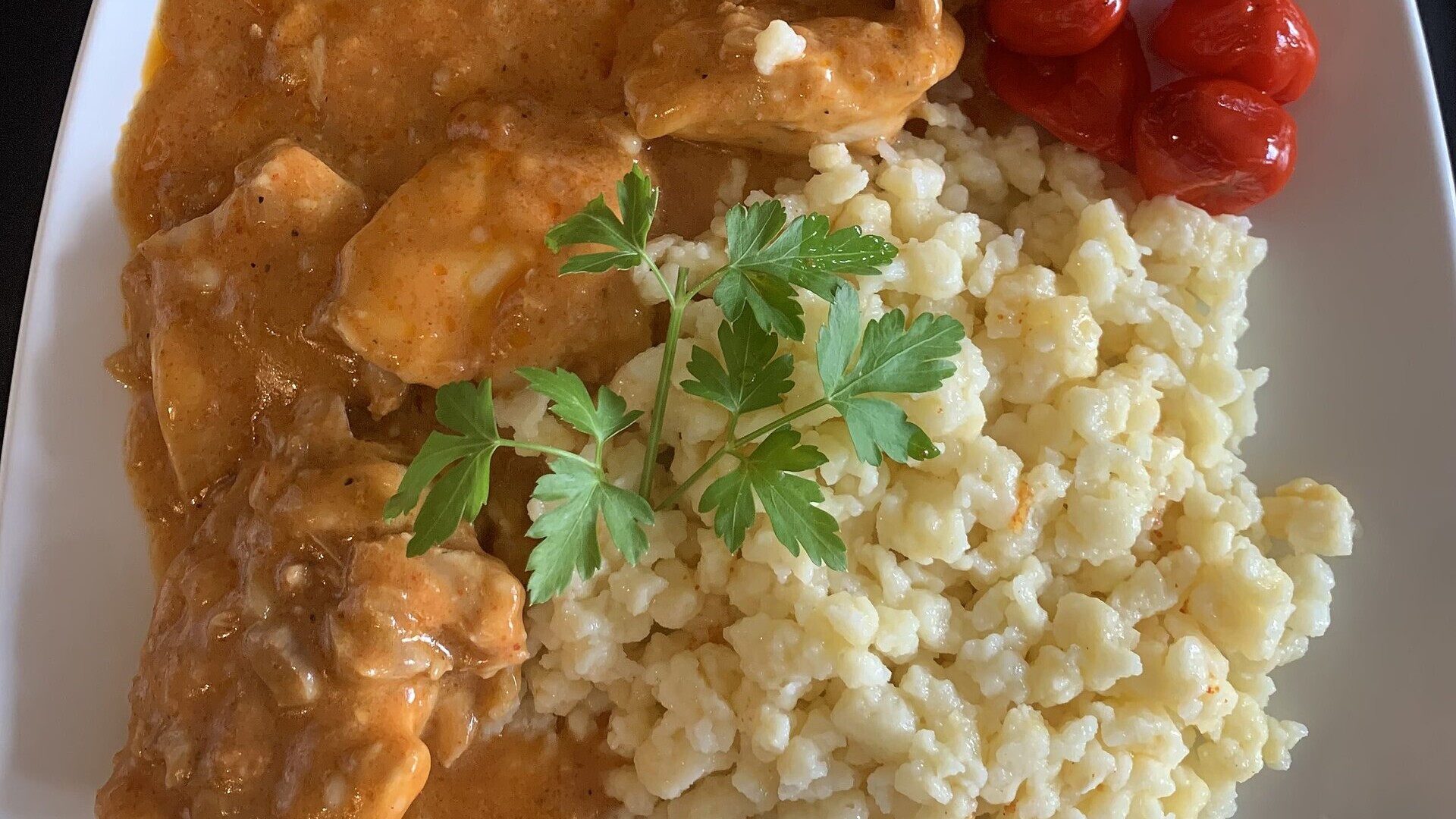 Hungarian recipes: chicken paprikash with nokedli egg dumplings on a white plate