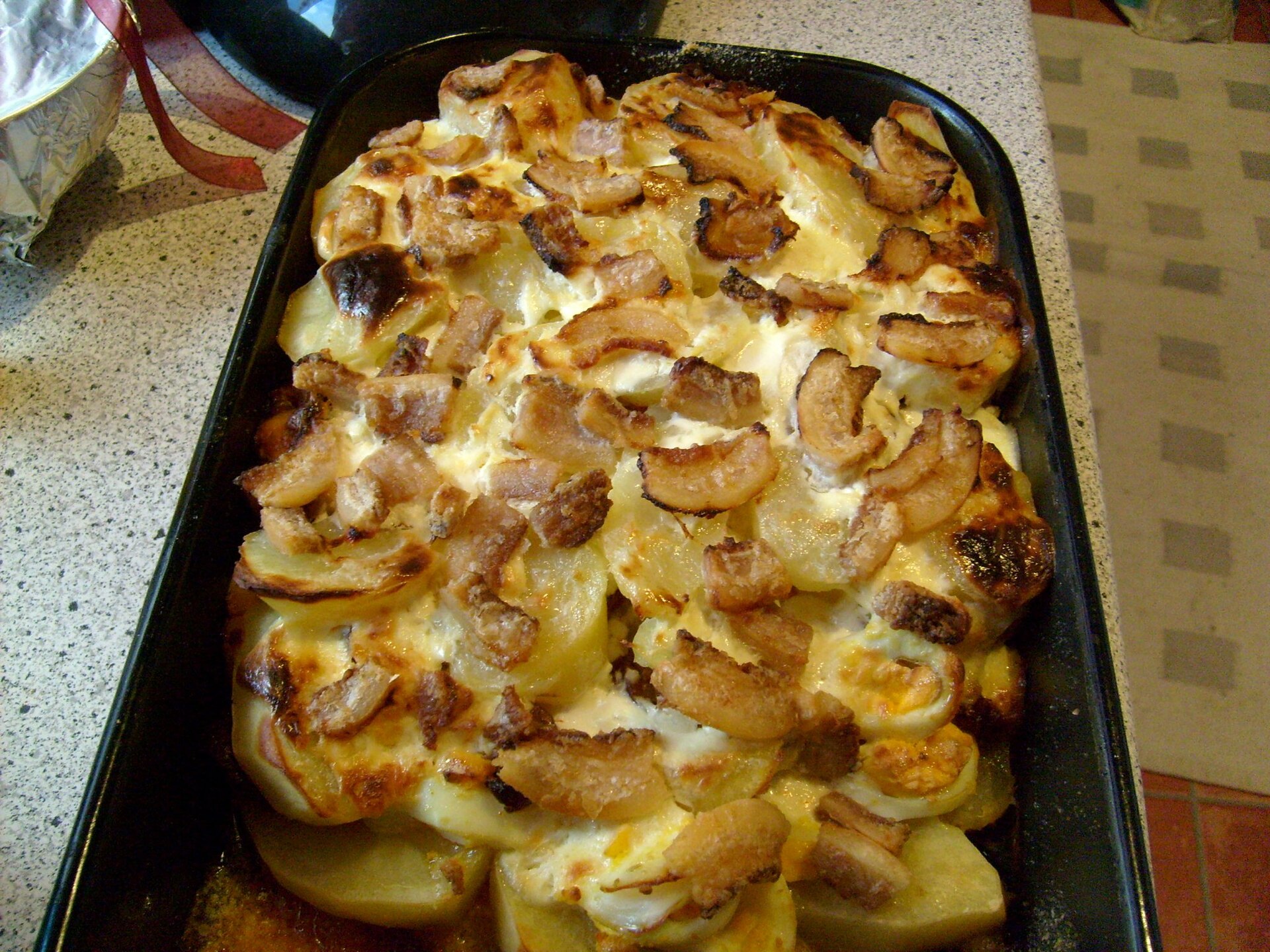 Layered potato bake with egg and sausage in a baking pan