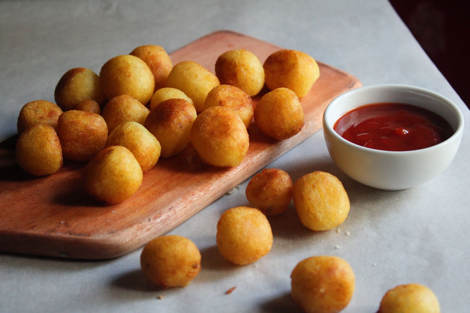 Crispy fried potato balls with a bowl of ketchup