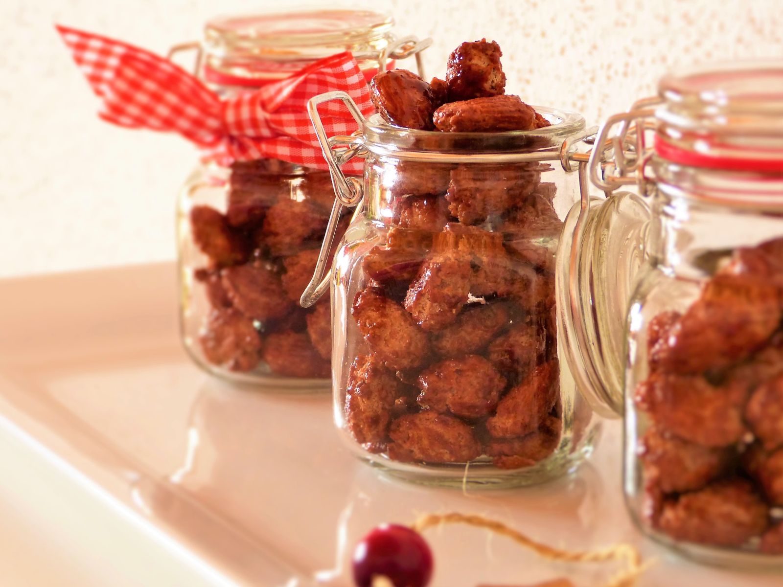 Cinnamon candied almonds in glass jars with red checked bows
