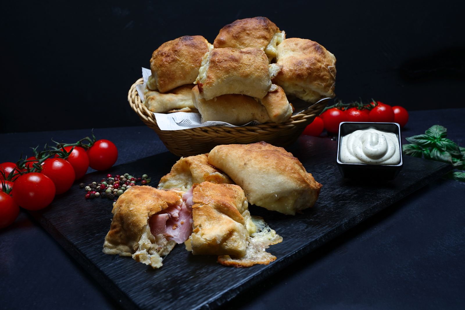 Basket of homemade ham and cheese pastries with dipping sauce