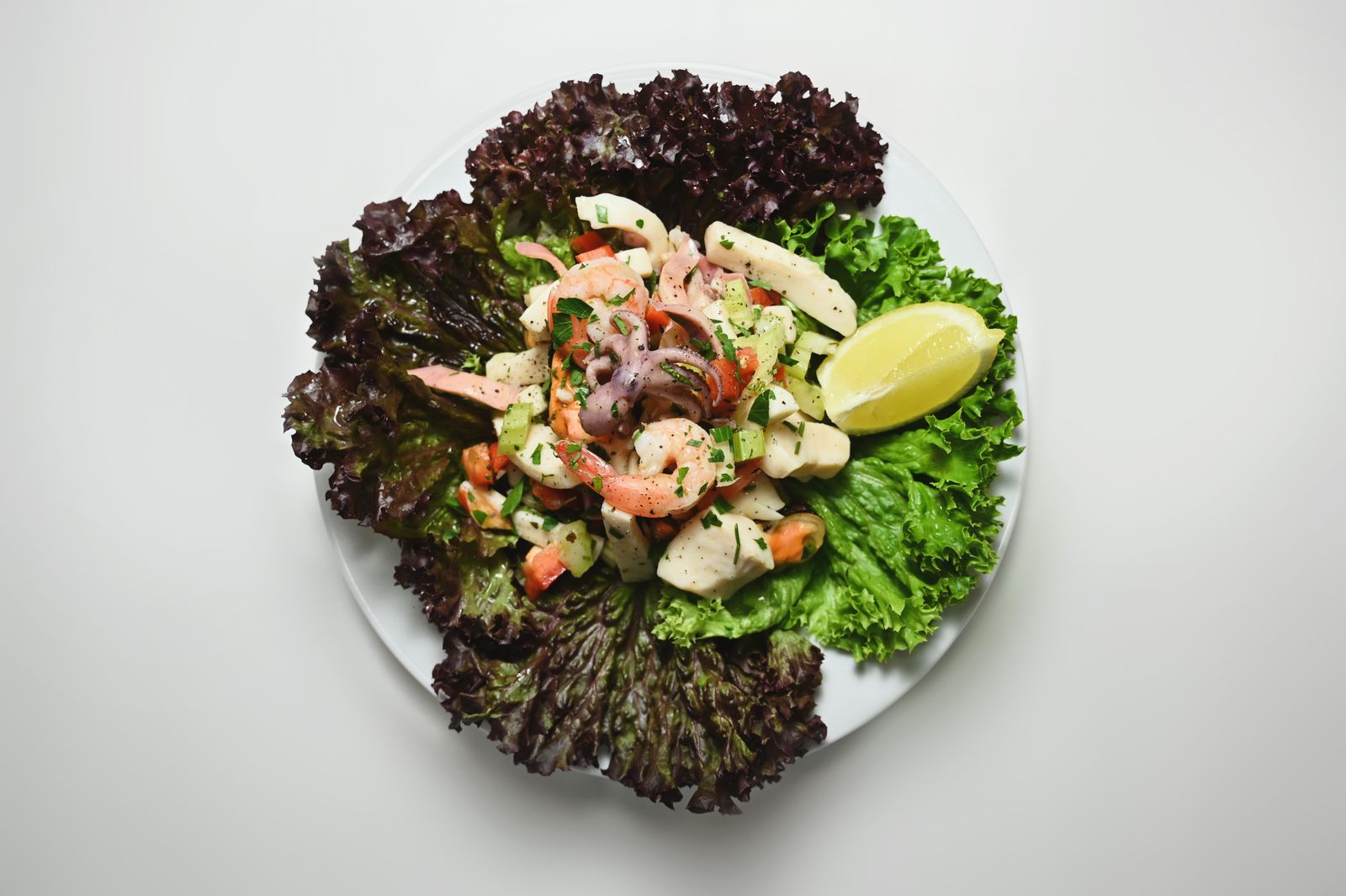 Seafood salad with fresh greens and a lemon wedge