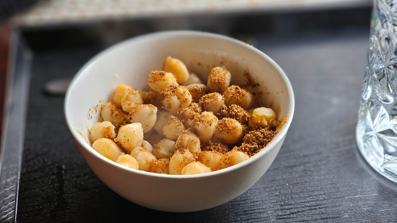 Bowl of glazed seasoned nuts on a table