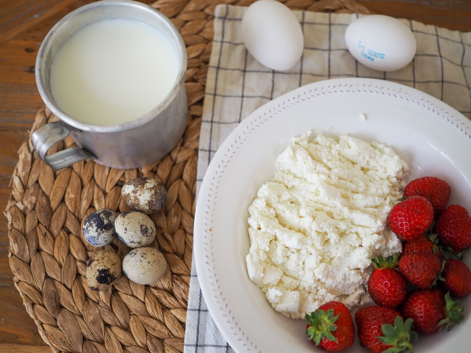 Bowl of fresh farmer cheese with strawberries and milk