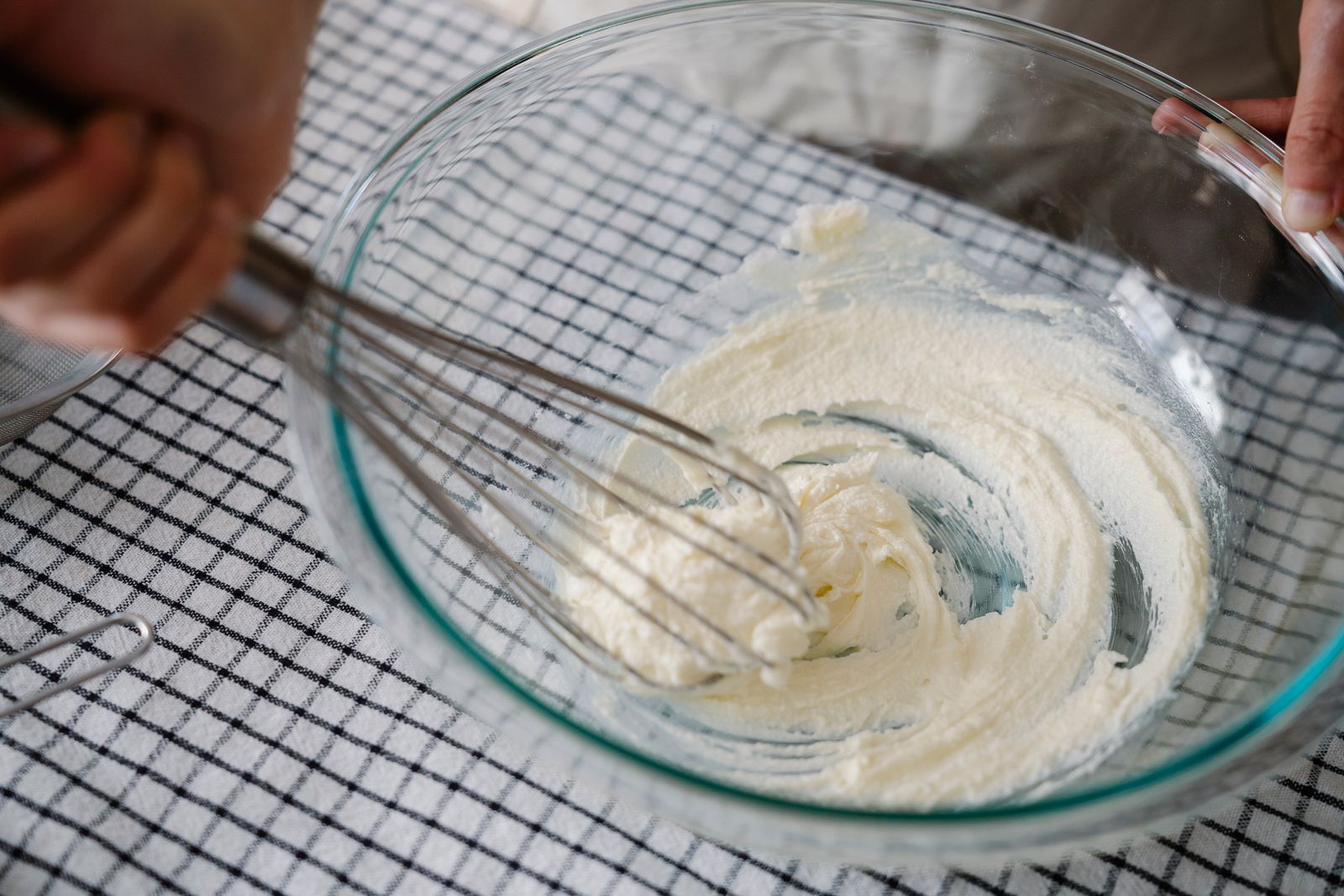 Soft butter being whipped in a glass bowl