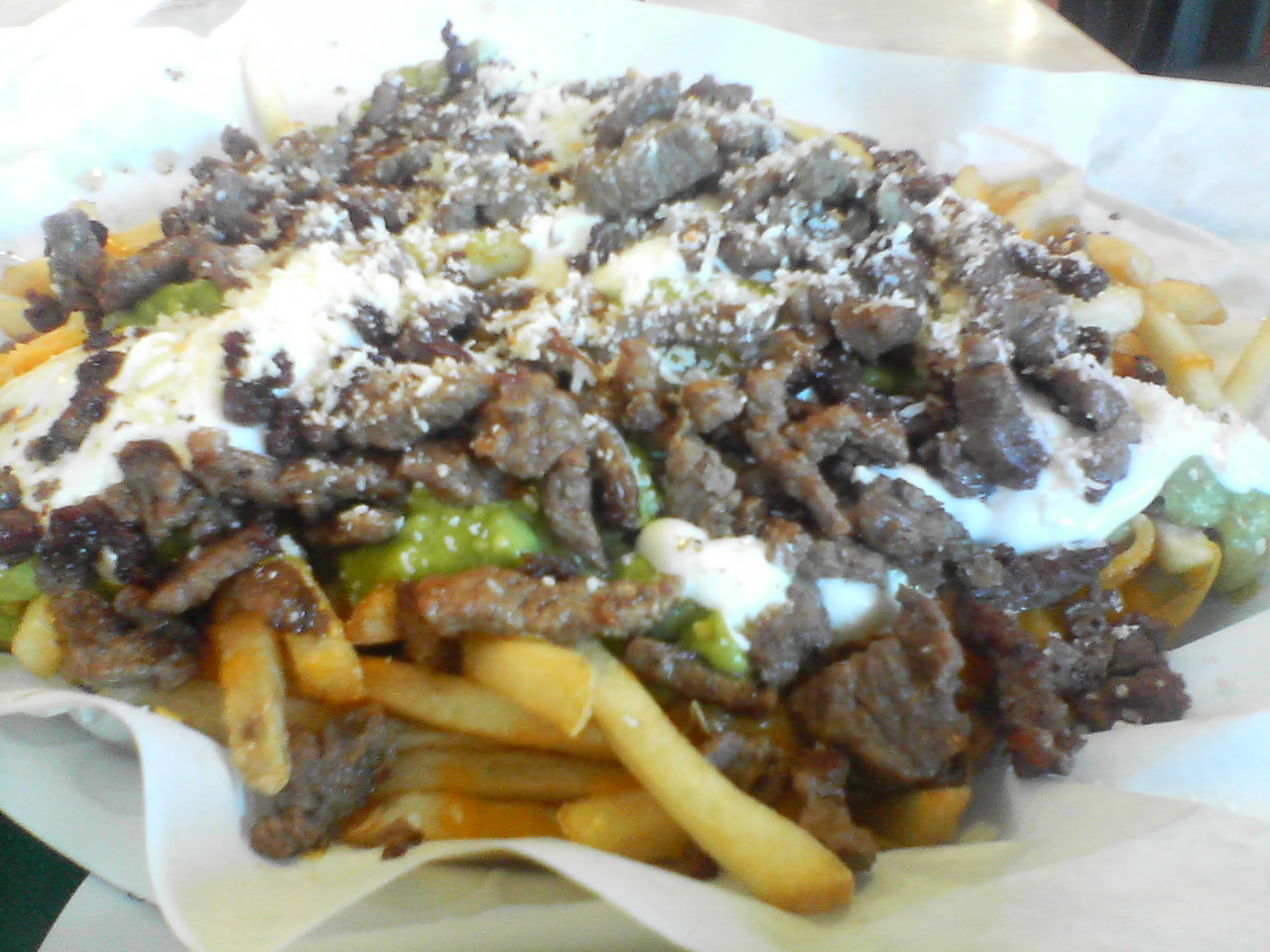 Grilled steak, cheese and guacamole piled on potatoes