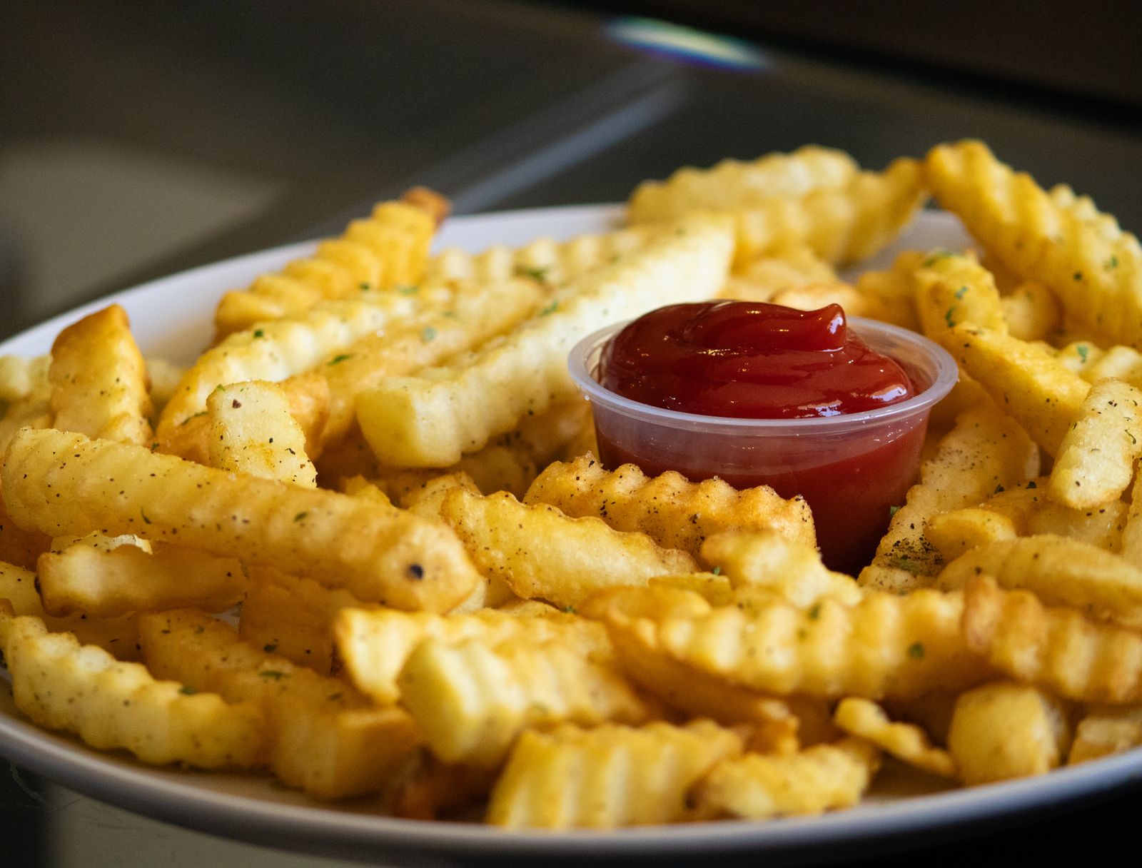 Crinkle cut french fries with ketchup on a plate, homemade fries
