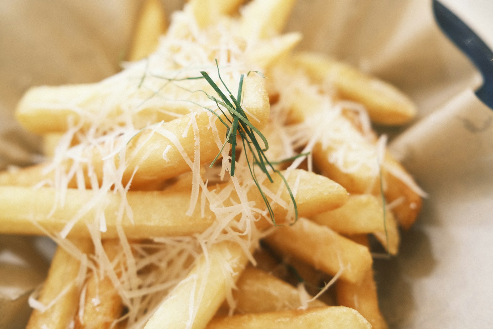 Fries topped with grated Parmesan and chives, homemade fries