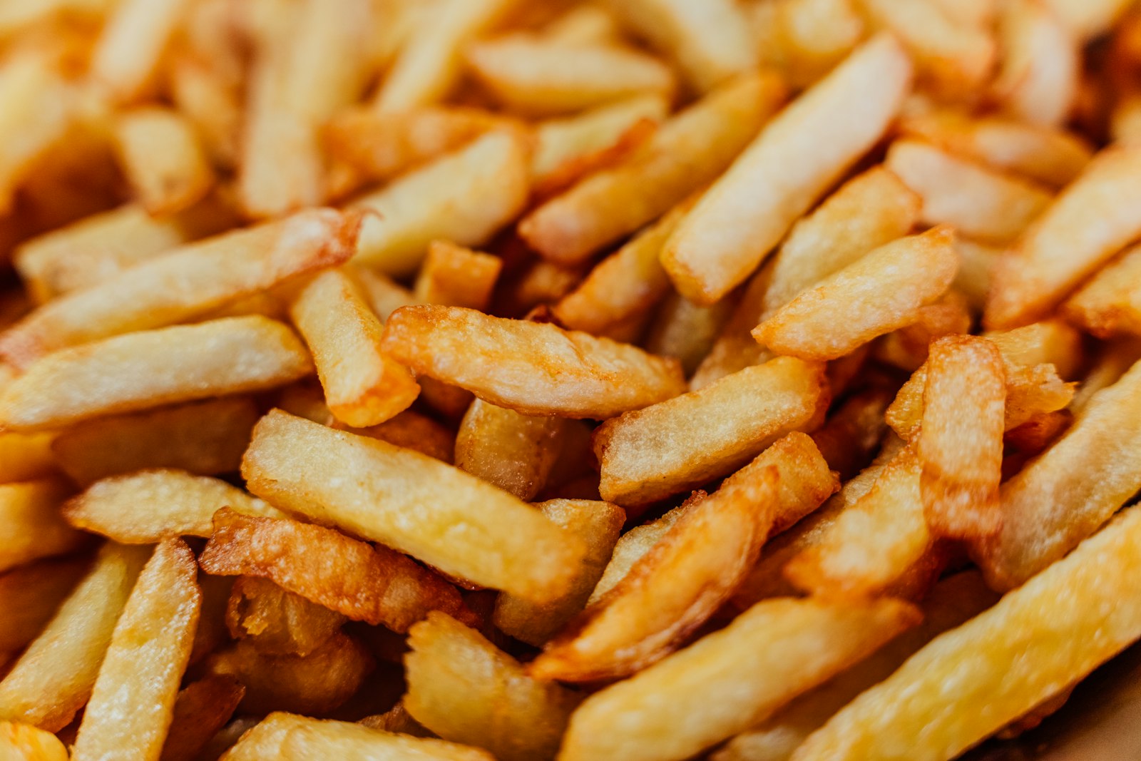 Golden skin-on potato sticks piled on a table