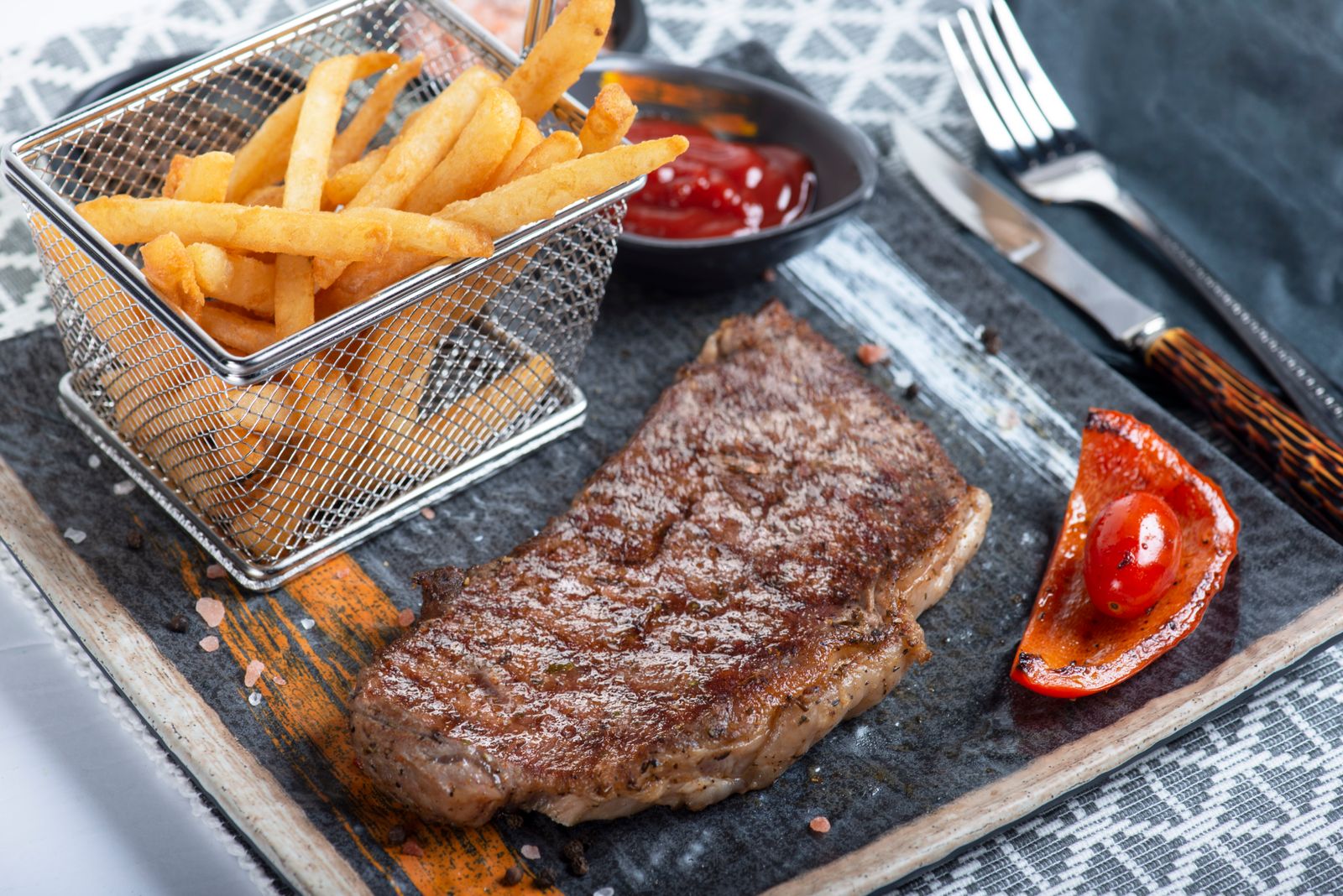 Thick cut steak fries served with steak on a wooden board, homemade fries