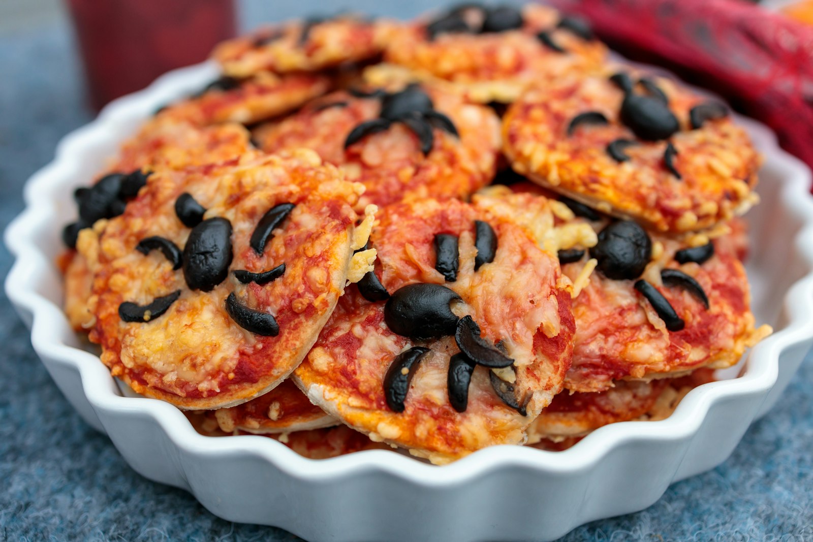 Tray of mini pizzas with cheese and olives, easy party appetizers