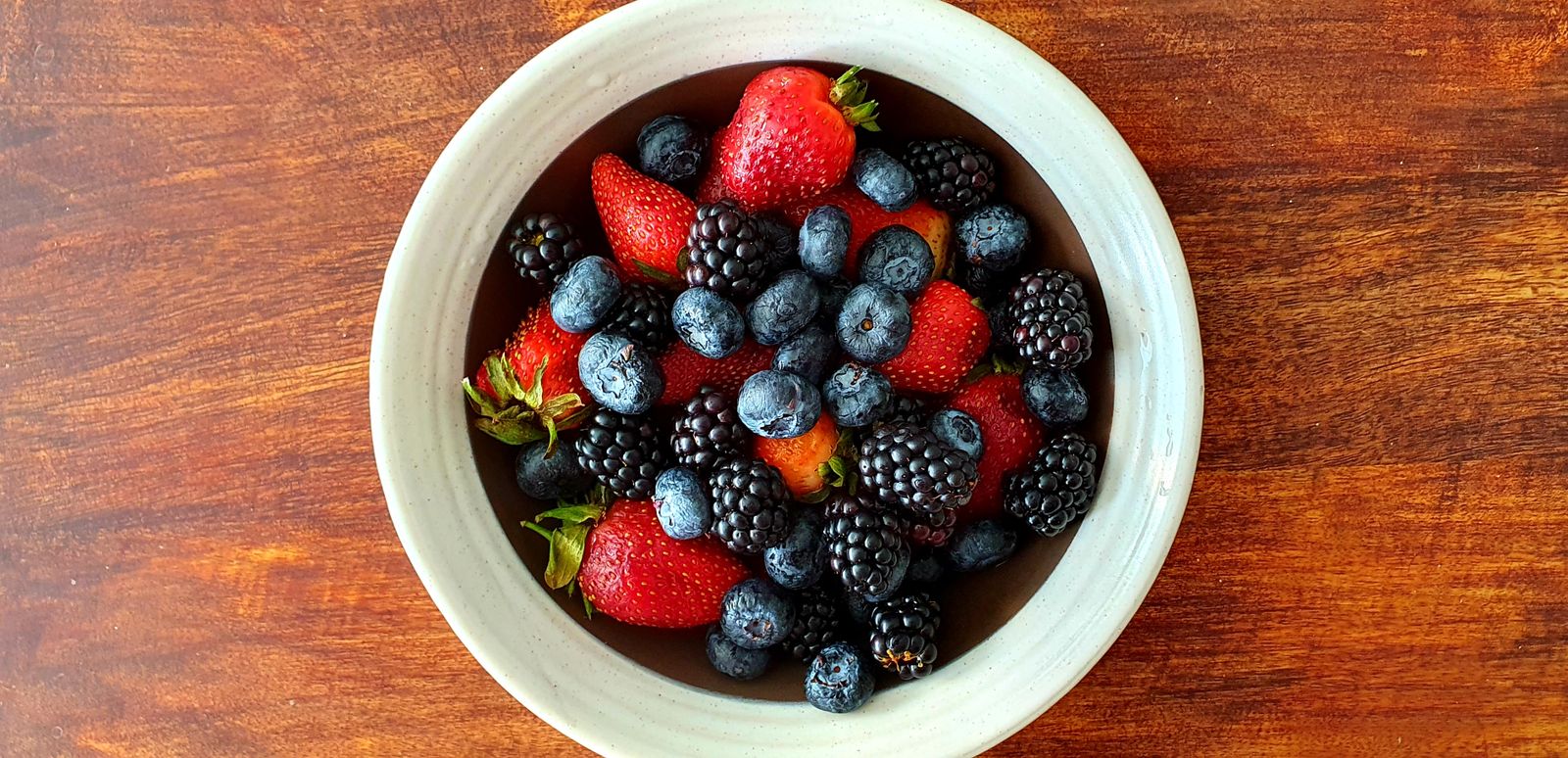 Mixed berries in a white bowl, part of the Bryan Johnson routine