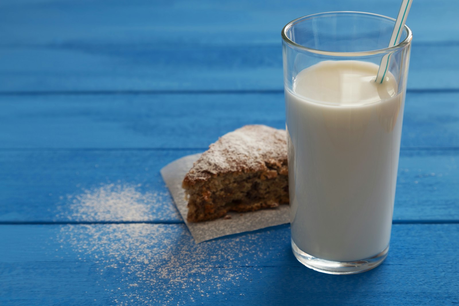 A glass of creamy nut milk on a blue table, as in Bryan Johnson recipes