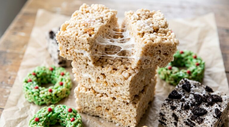 Stack of tall Rice Krispie treats pulled apart with gooey marshmallow strings and holiday treats