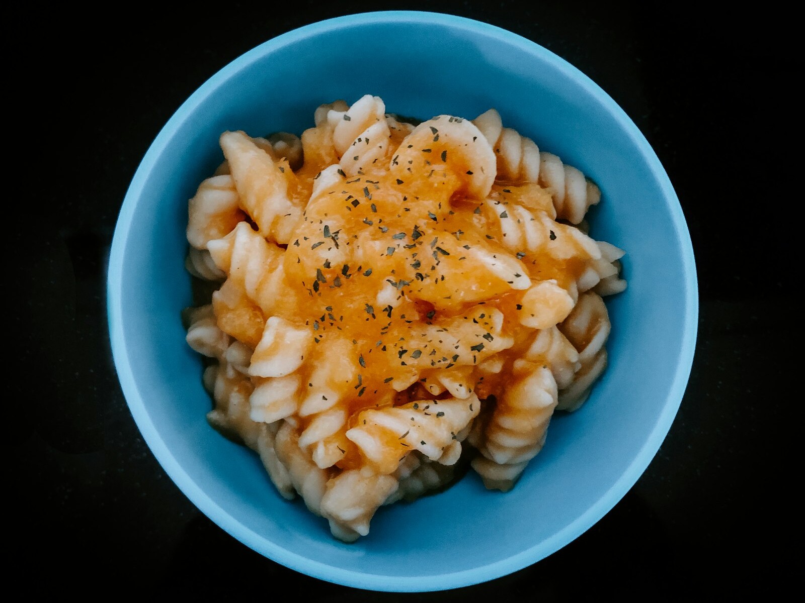 Bowl of buffalo sauce pasta with a spicy drizzle