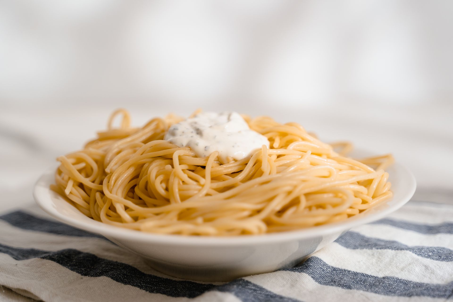 Buttered noodles with Parmesan on a white plate