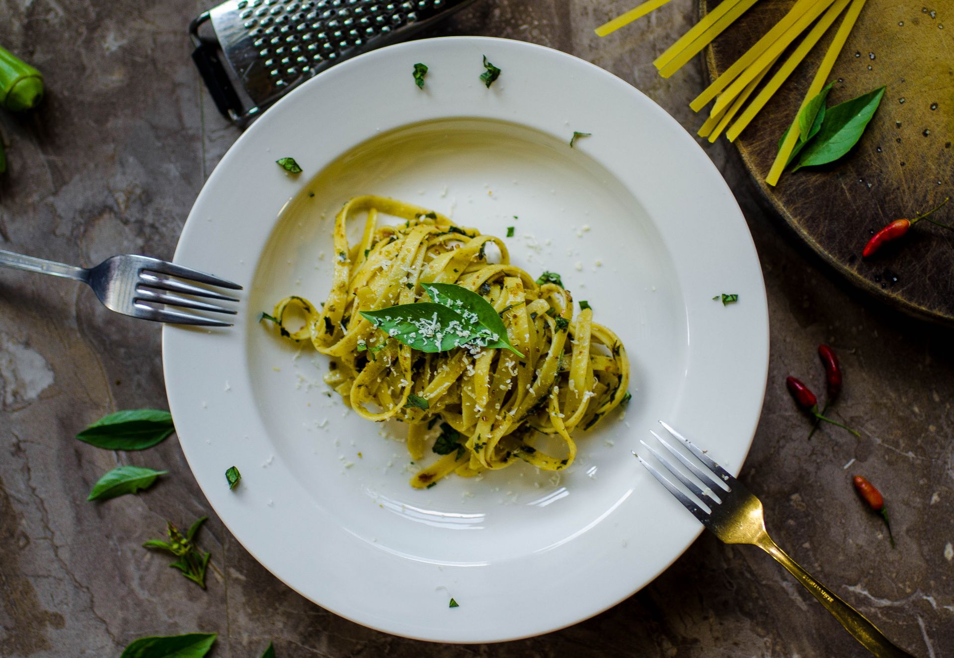 One-pot pasta with basil pesto and Parmesan on a white plate