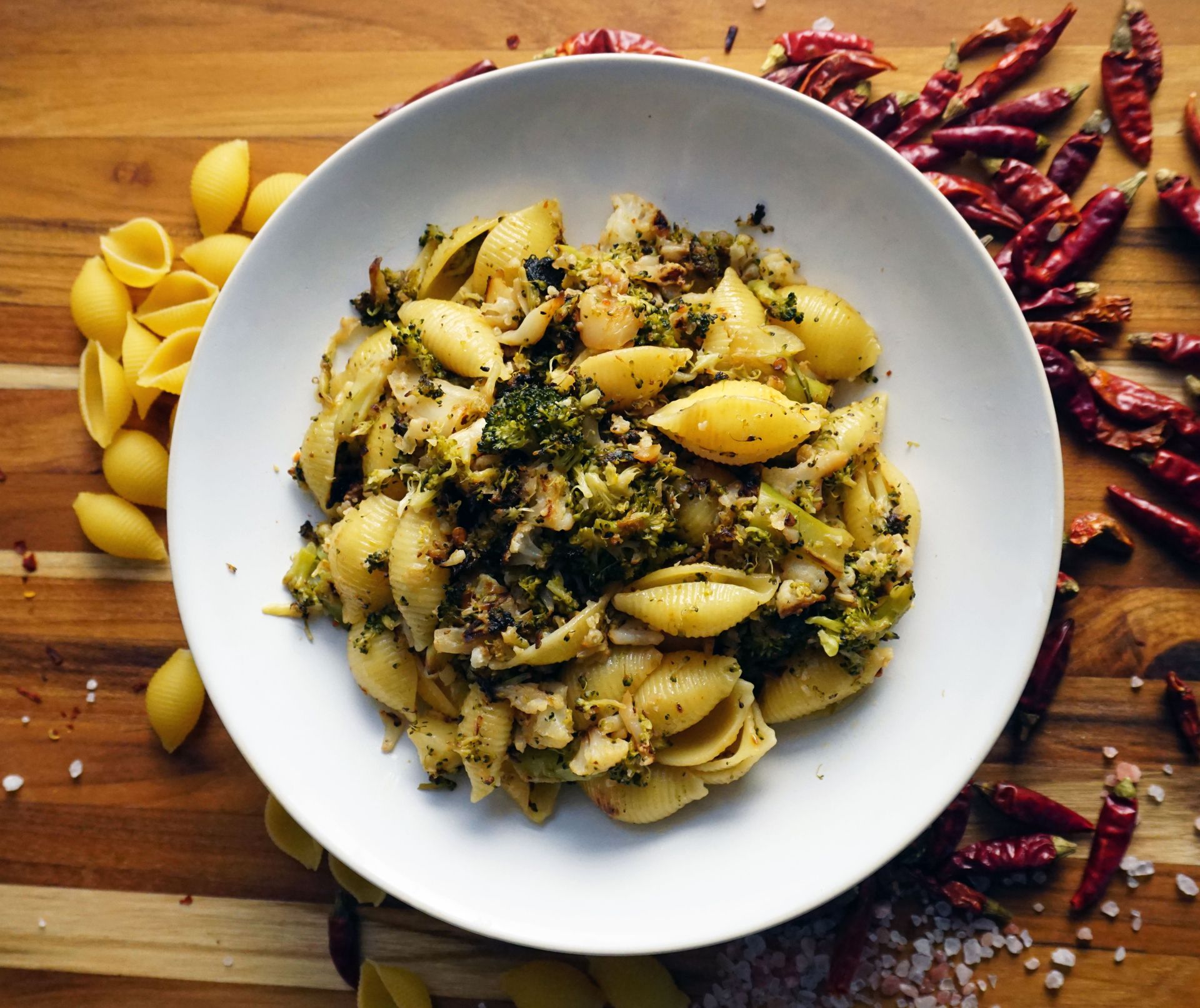 Pasta shells with broccoli and chili flakes in a white bowl