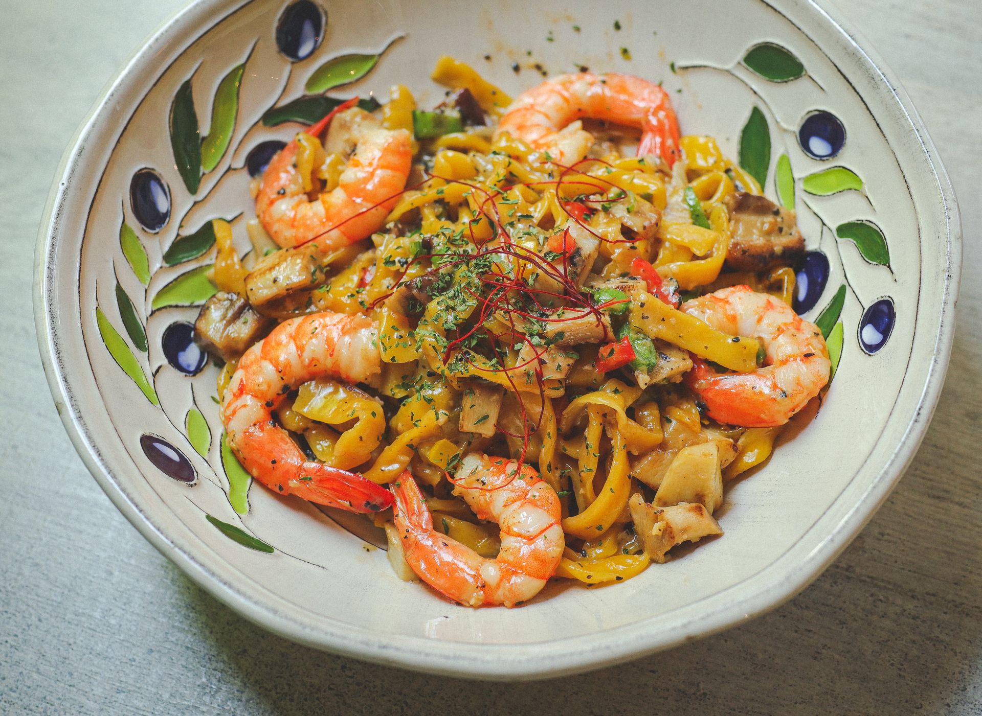 Lemon garlic shrimp pasta with herbs in a white ceramic bowl