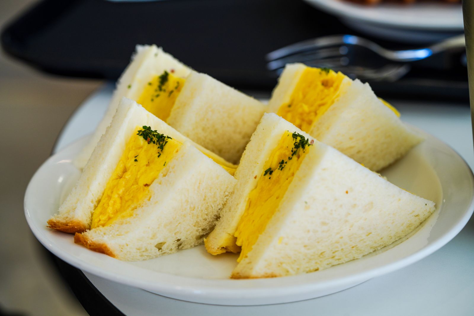 Egg salad sandwich on soft bread cut in half, old fashioned sandwiches