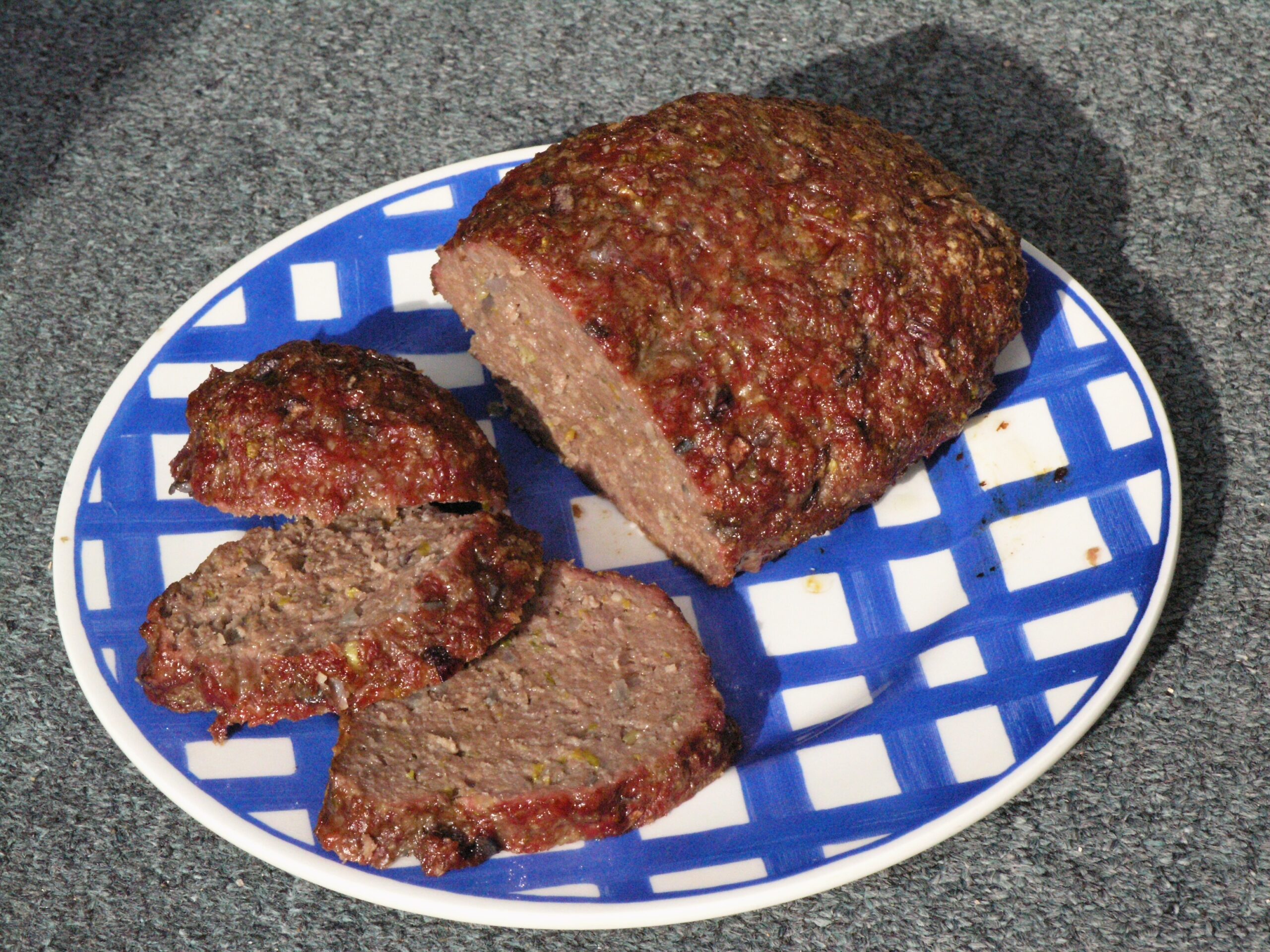 Thick slices of meatloaf on a blue checked plate