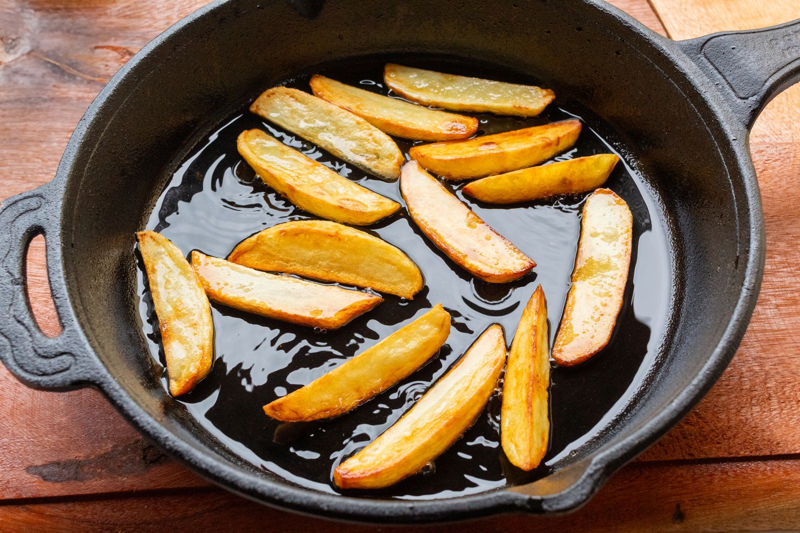 Pan fried potato slices in a cast iron skillet for sandwiches