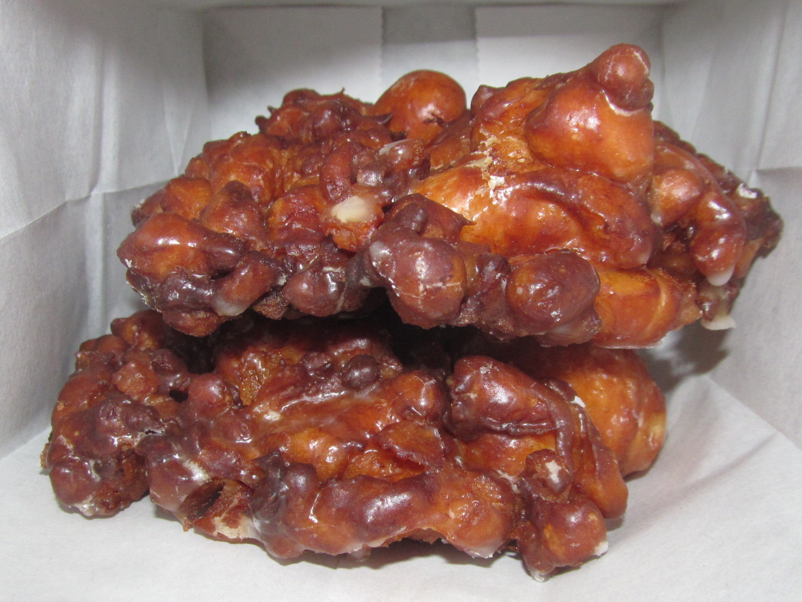 Glazed apple fritters cooling after frying