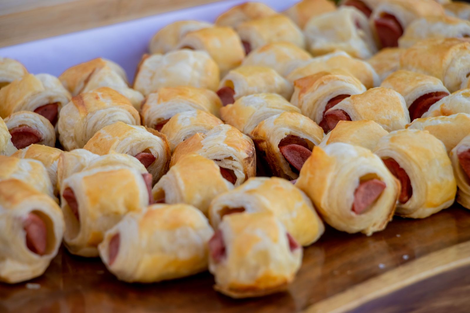 Pigs in a blanket on a wooden tray