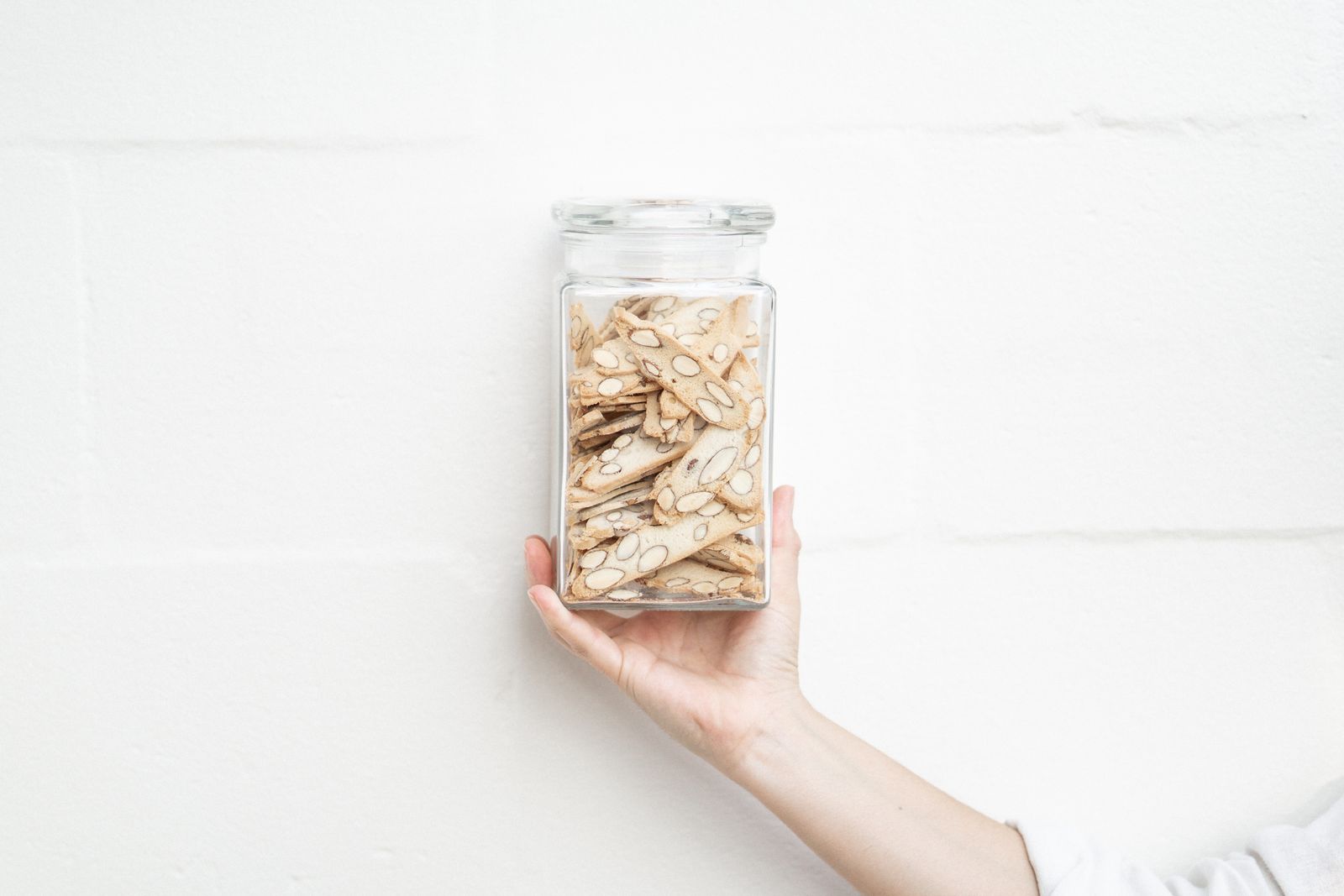 Biscotti gift: a hand holding a glass jar filled with almond biscotti