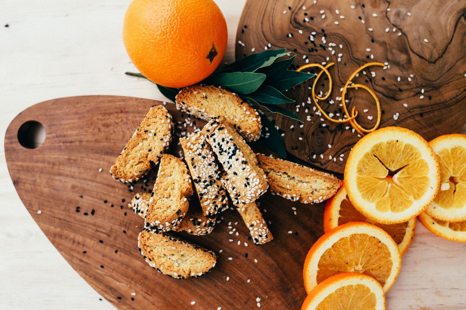 Sesame cookies with fresh orange slices on a wooden tray