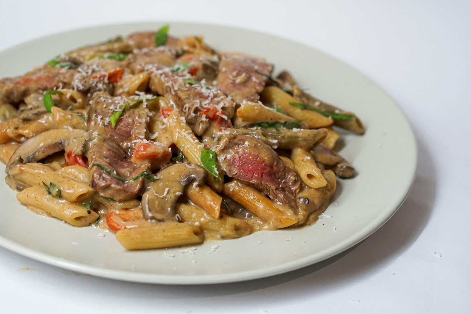 Creamy beef pasta on a white plate