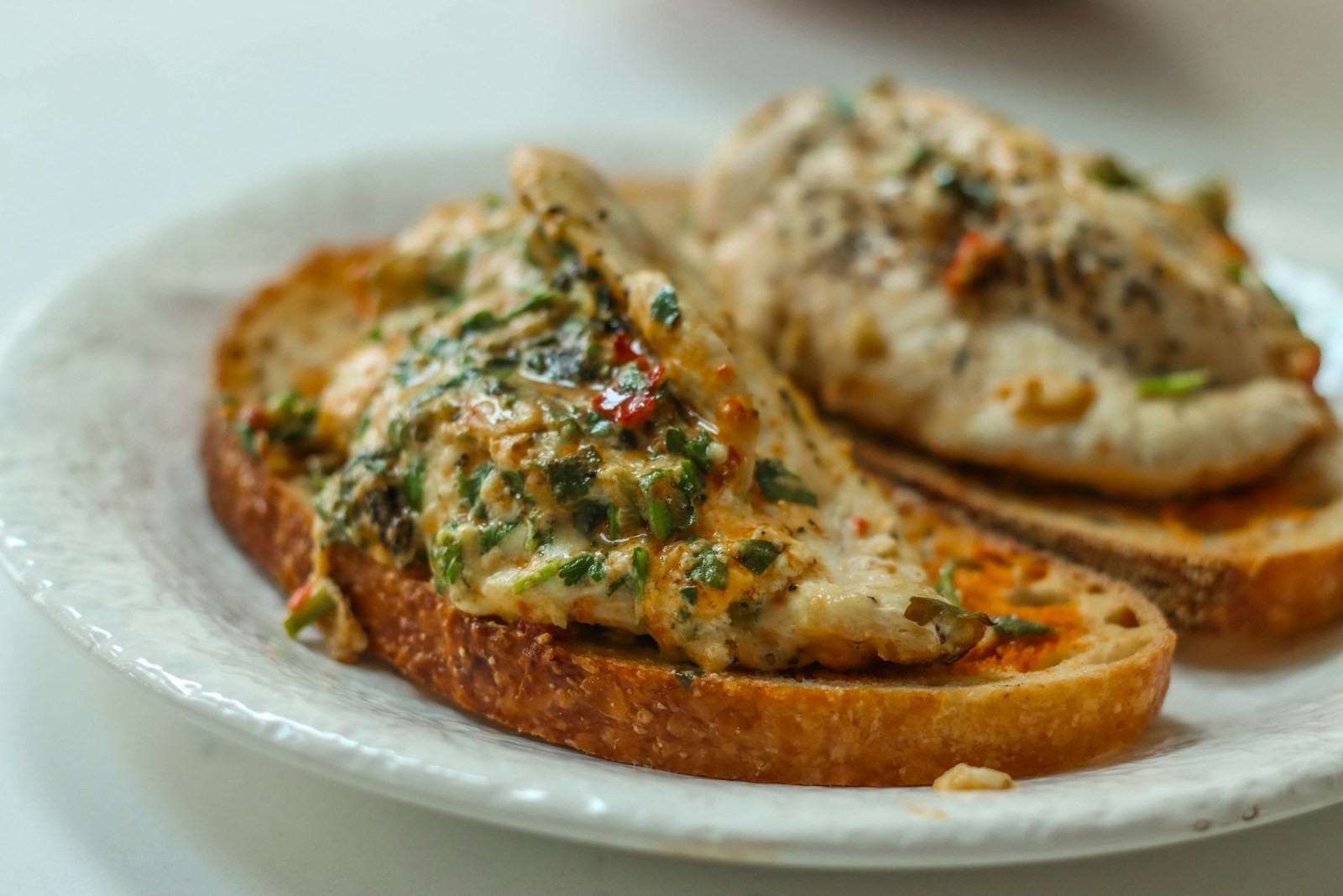 Creamy herbed chicken piled on toasted sourdough slices