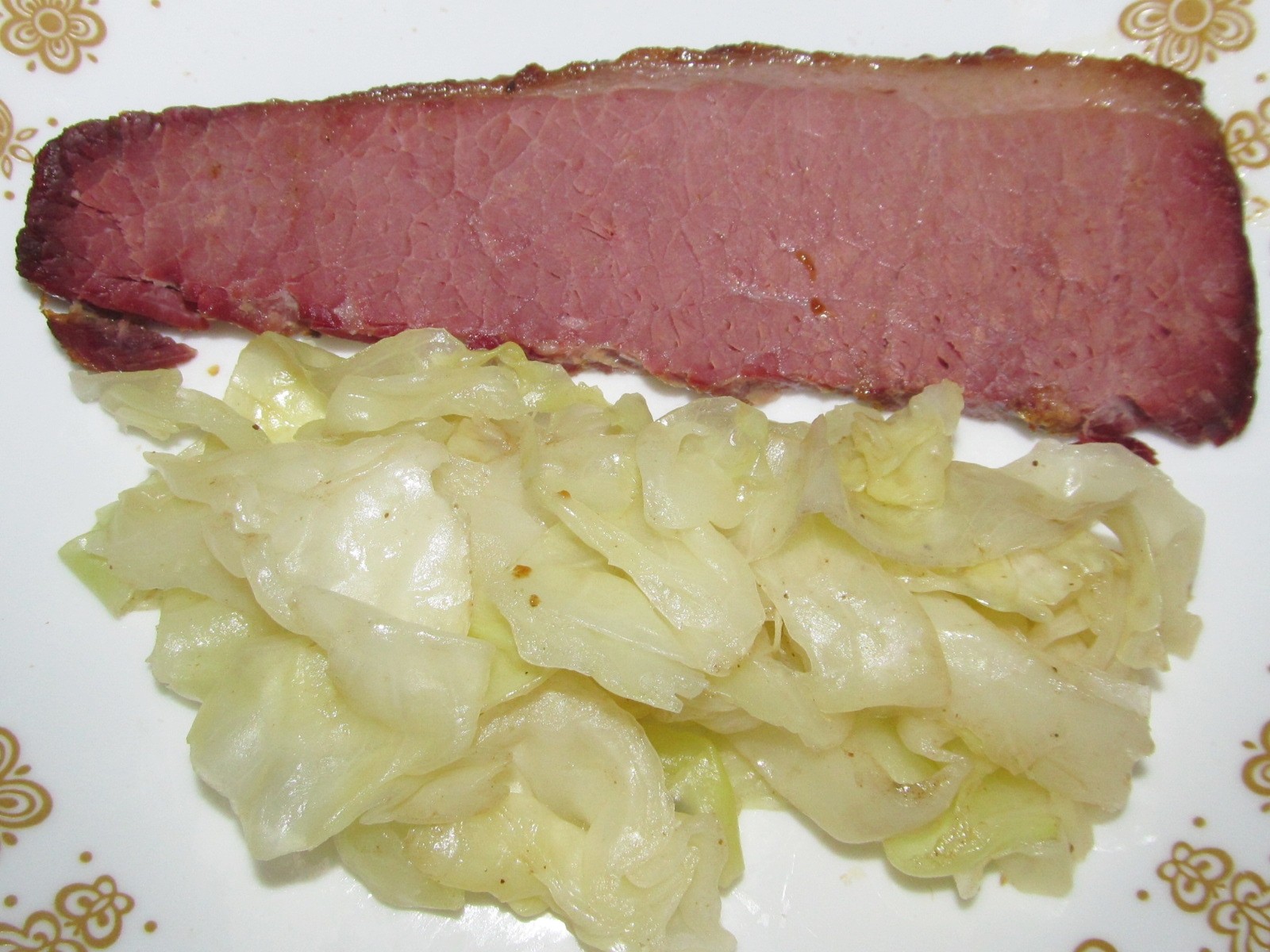 Slice of corned beef with buttery soft cabbage on a plate