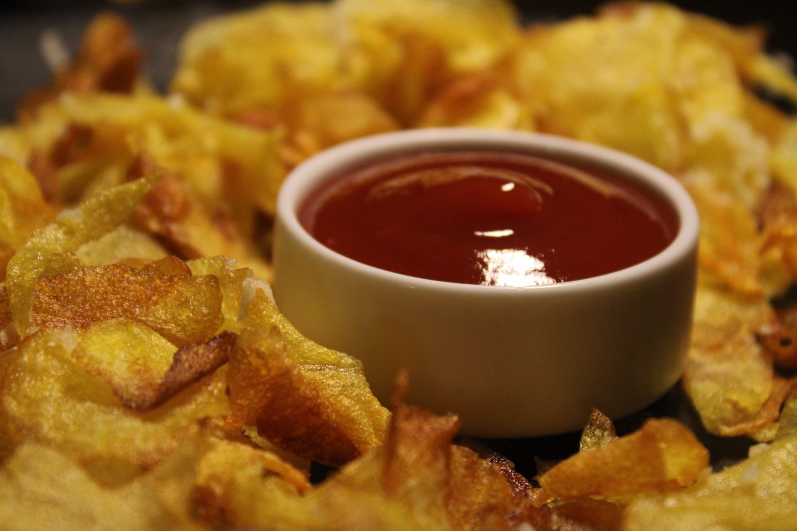 Homemade ketchup in a bowl with crispy potatoes