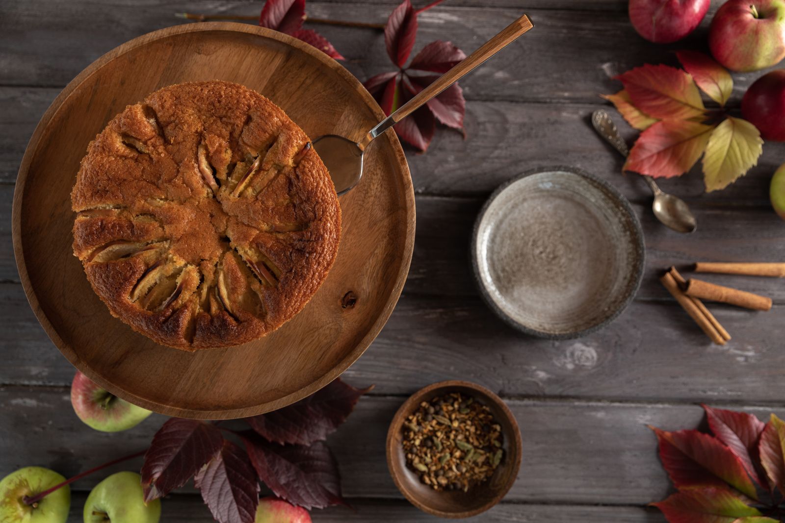 A homemade apple cake with apples and cinnamon sticks