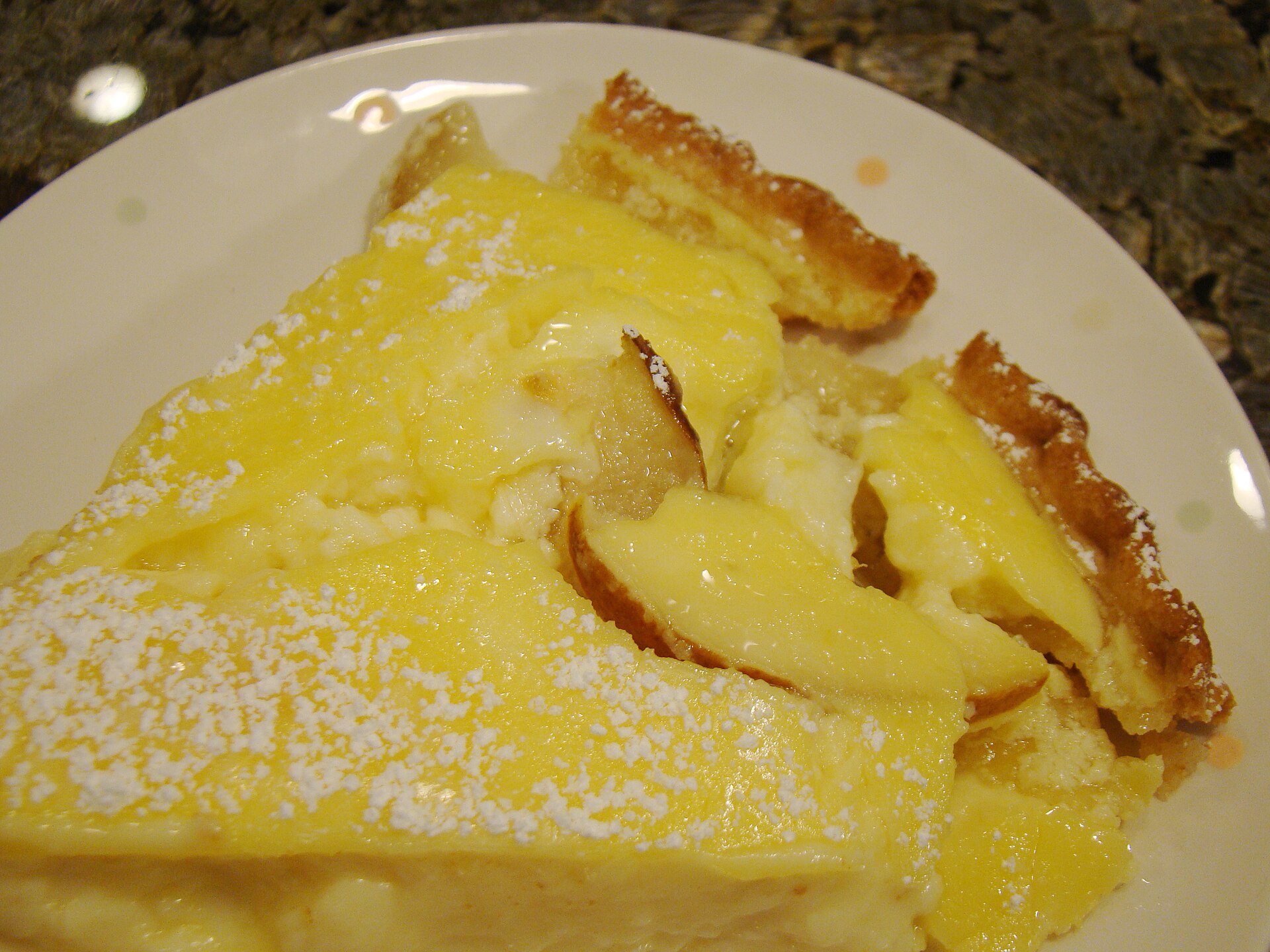 A slice of lemon custard pie dusted with sugar