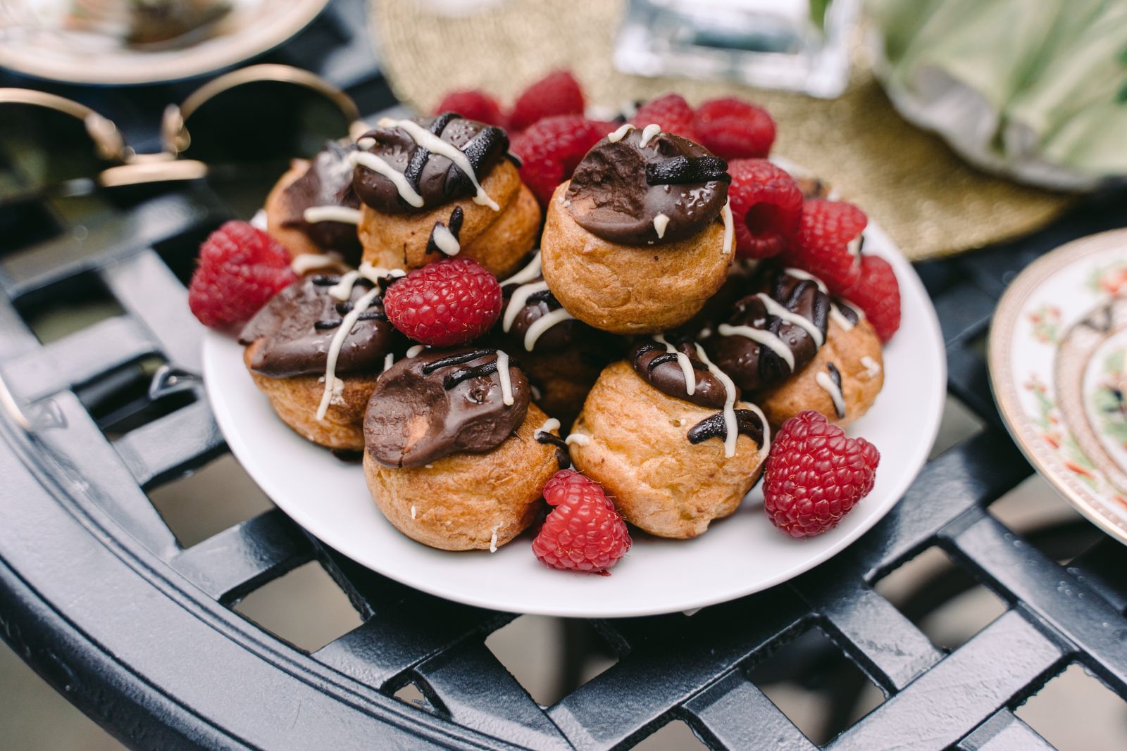 Cream puffs with chocolate glaze and fresh raspberries