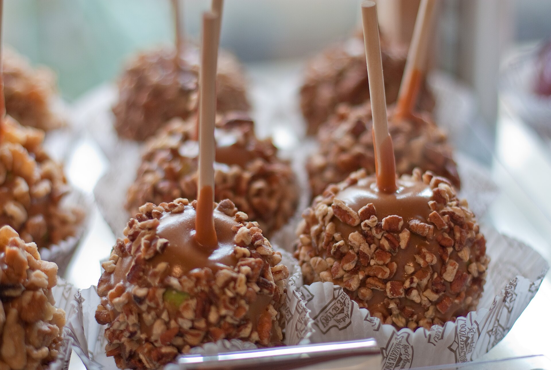 Caramel apples rolled in chopped nuts on sticks