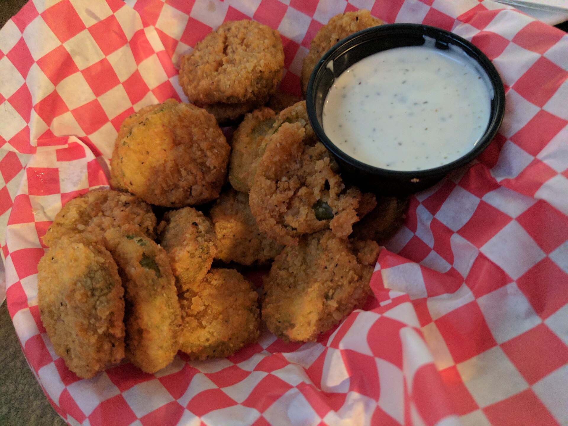 State fair foods at home: fried pickle chips in a checkered basket with ranch