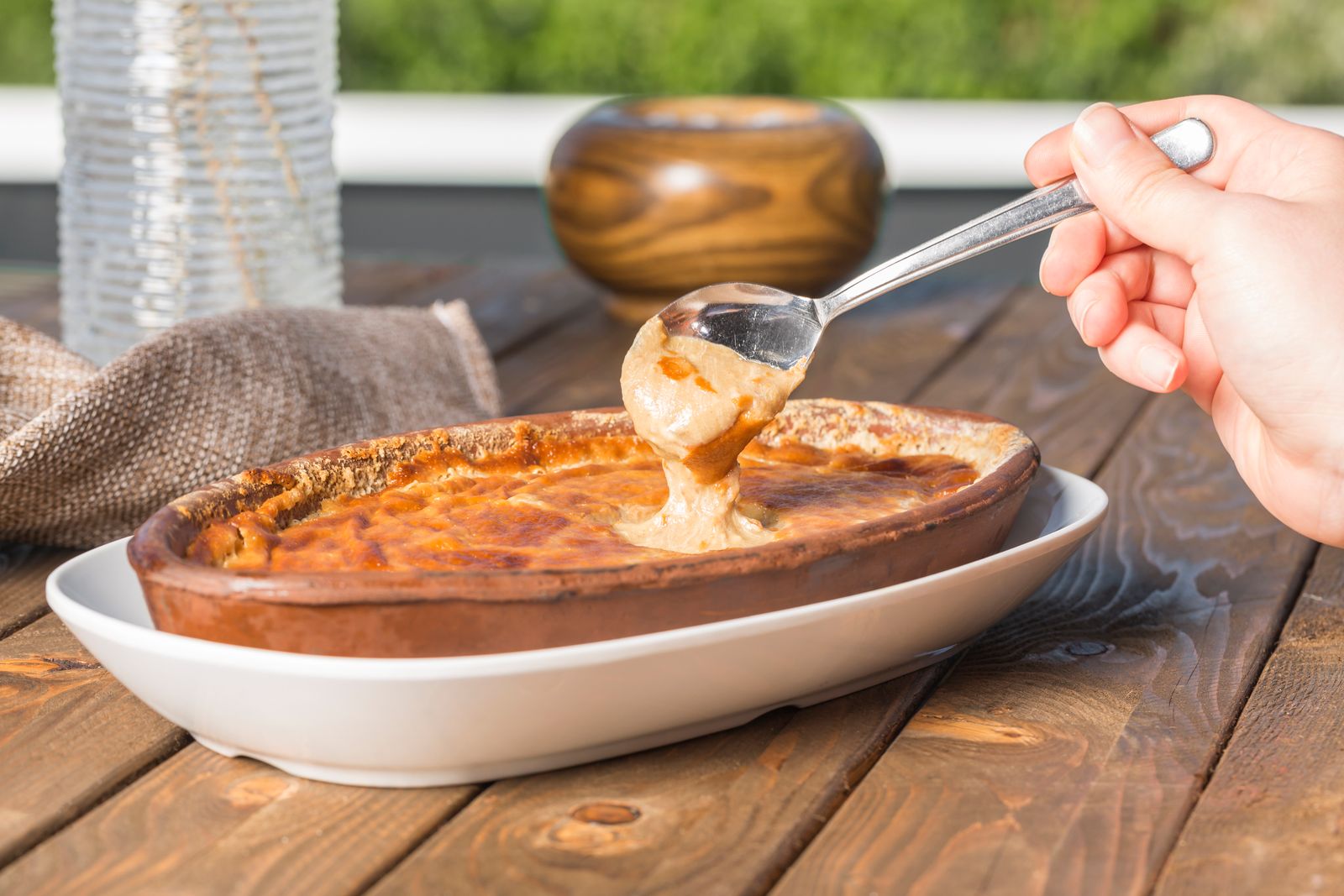 A hot baked casserole being served with a spoon