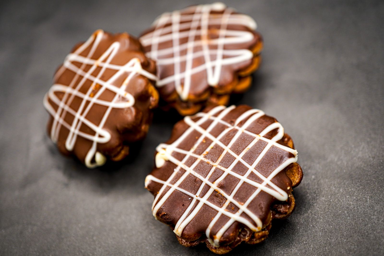 Chocolate coated treats with a white chocolate drizzle