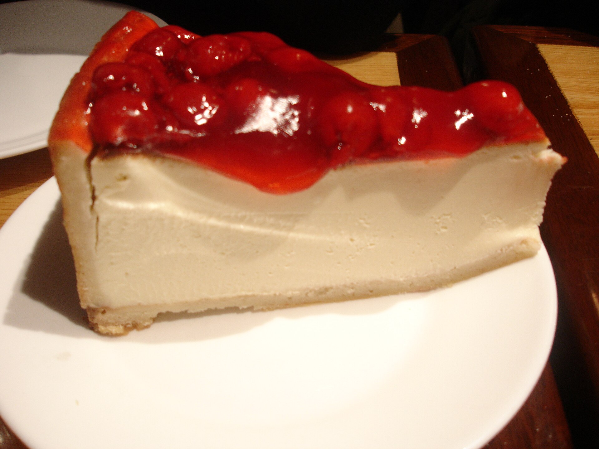 A slice of cherry cheesecake on a graham cracker crust